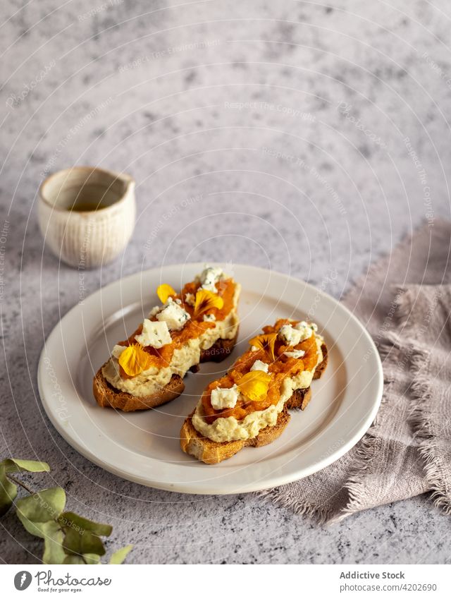 Plate with pumpkin toasts with jam and sweet cheese snack tasty yummy arrangement homemade organic wholesome healthy baked food table cuisine nutrition culinary