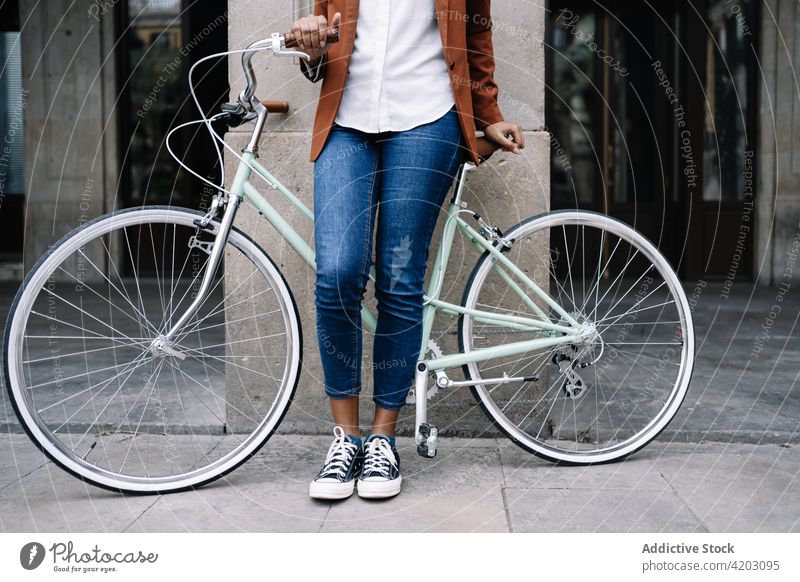 Ethnic woman standing with bicycle along street commute city smart casual bike walk trendy style female black african american ethnic urban contemporary vehicle