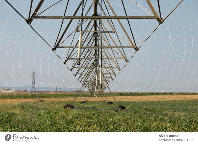 Irrigation pivot, with water or chemigation, fed by pipeline, example of agricultural machinery and agro-industrial infrastructures in crop fields in Aragon.