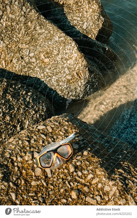 Closeup of some diving goggles on some rocks on the beach water sea close up vacation summer travel nature tropical ocean blue holiday snorkel equipment leisure