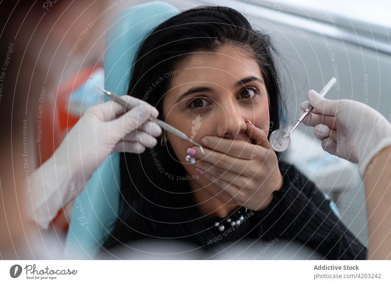 Scared patient covering mouth with hands from dentist woman fear scared medicine specialist work cover mouth clinic female young person job occupation