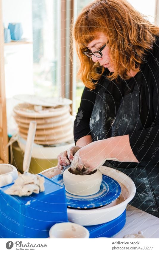 Woman sculpturing pot with clay craftswoman shape equipment wheel design process skill molding handicraft sculptor professional workshop art instrument