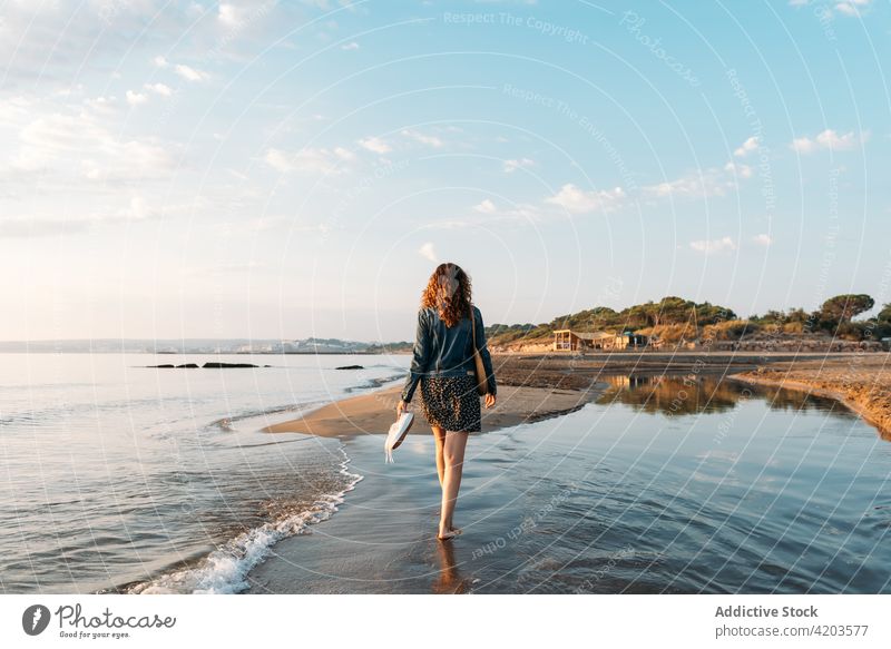 Anonymous woman walking against sea and sunset sky sundown admire summer female water tranquil scenery evening spectacular nature serene scenic calm harmony