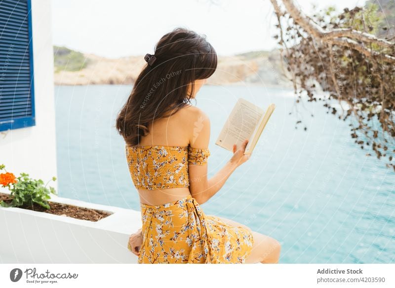 Young woman reading book near lake summer terrace countryside rest enjoy romantic calm young female water novel summertime story literature relax hobby