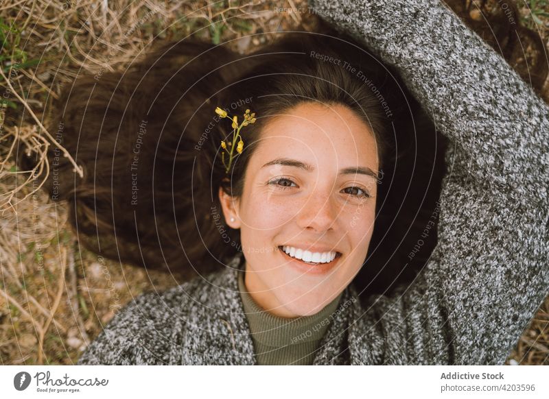 Happy woman lying on grassy meadow happy nature smile flower enjoy portrait spring cheerful young female human face traveler positive bloom blossom content