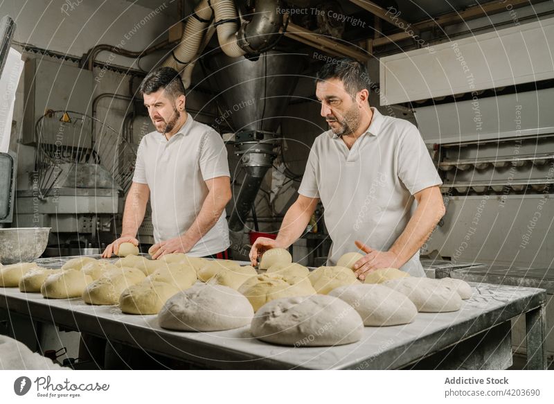Ethnic bakers preparing bread at table in kitchen prepare form dough professional colleague natural men bakery ethnic coworker bowl flour similar attentive