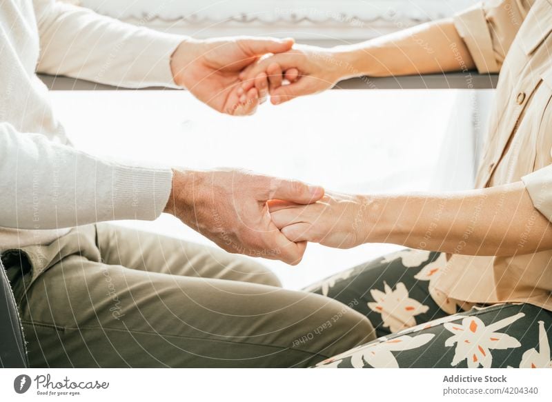 Loving adult couple holding hands at home mature love tender counter kitchen together spend time in love affection fondness relationship bonding sit stool enjoy