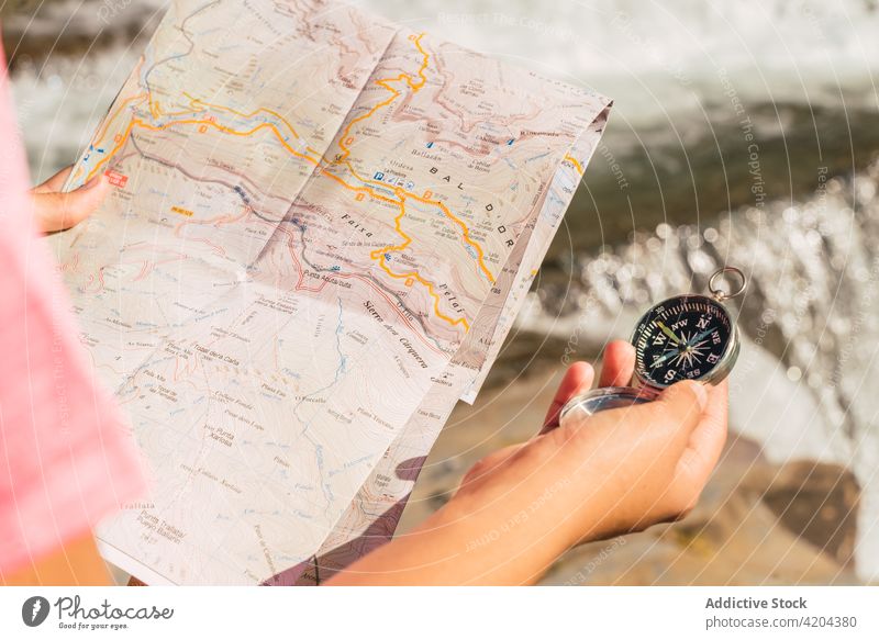 Unrecognizable female hiker navigating with map in highlands woman orientate travel navigate mountain waterfall guide explore traveler pyrenees huesca spain