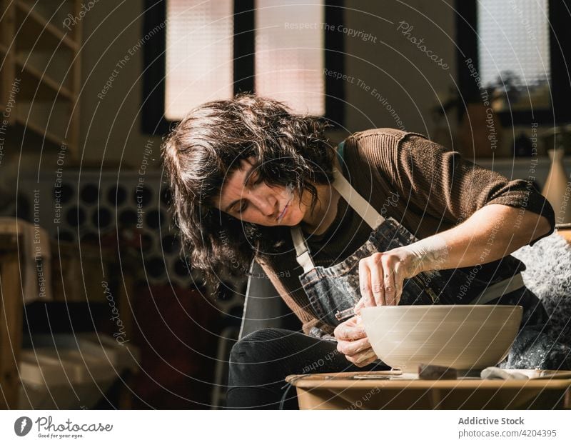 Female ceramist making clay bowl in studio pottery wheel craftswoman create clayware workshop earthenware artisan ceramic female focus handmade handicraft