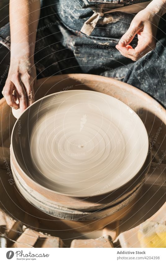 Crop ceramist creating clayware in workshop craftswoman pottery wheel create earthenware handmade ceramic handicraft female artisan tableware hobby skill master