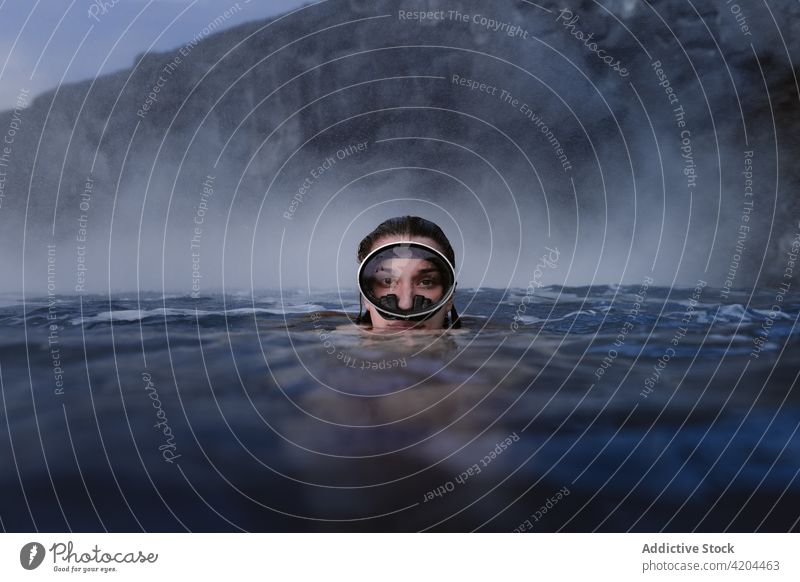 Woman with goggles diving into the sea looking at camera water underwater woman diving goggles mask ocean sport lifestyle summer fun holiday snorkel dive blue