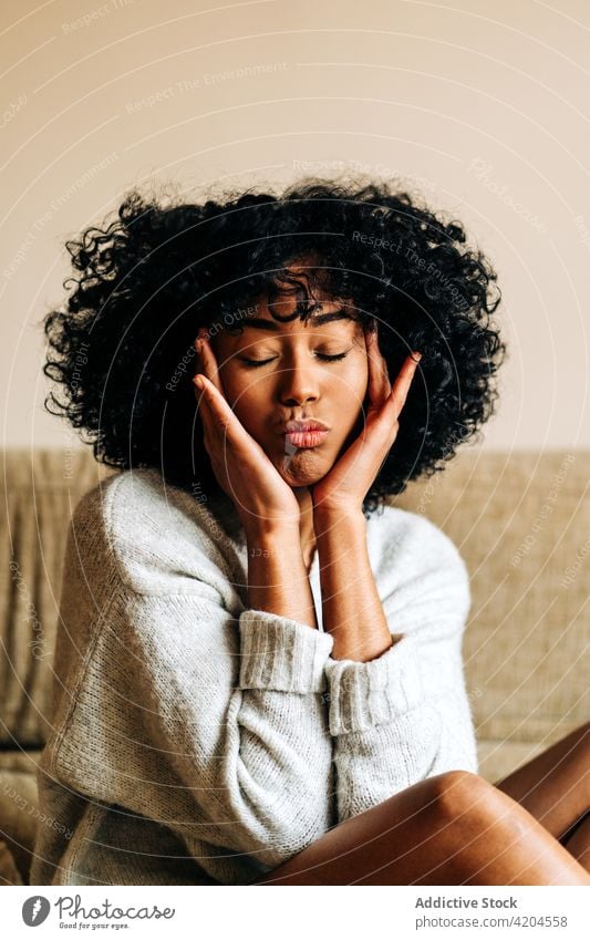 Tender black woman with pouting lips at home duck face tender make face gentle afro hairstyle feminine female ethnic african american curly hair harmony