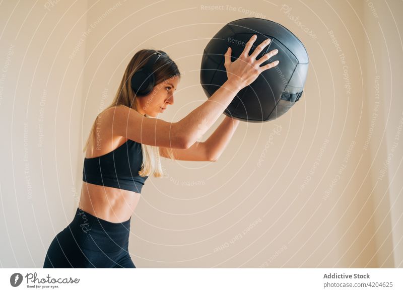 Woman wearing sportswear and helmets while holding a ball with her hands woman headphones music listen song melody hands up hobby dynamic sound lady female