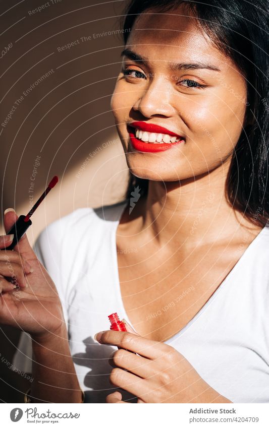 happy woman with makeup coloring lips smile red lips cheerful rouge apply lipstick portrait cosmetic glad female dark hair appearance personality human face