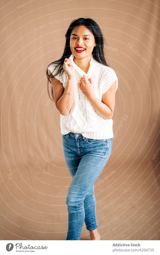 Happy ethnic woman in light studio satisfied cheerful happy glad optimist positive delight pleasant female smile toothy smile excited carefree appearance