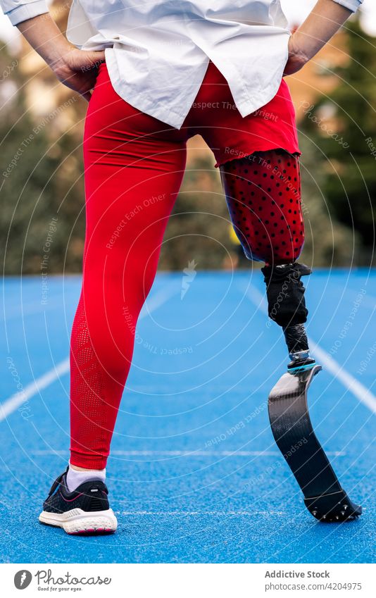 Unrecognizable sportswoman with leg prosthesis at stadium bionic runner professional athlete paralympic fit female limb artificial amputee disable workout