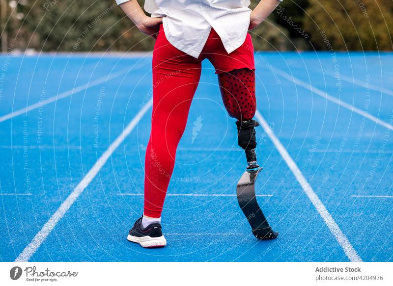 Unrecognizable sportswoman with leg prosthesis at stadium bionic runner professional athlete paralympic fit female limb artificial amputee disable workout