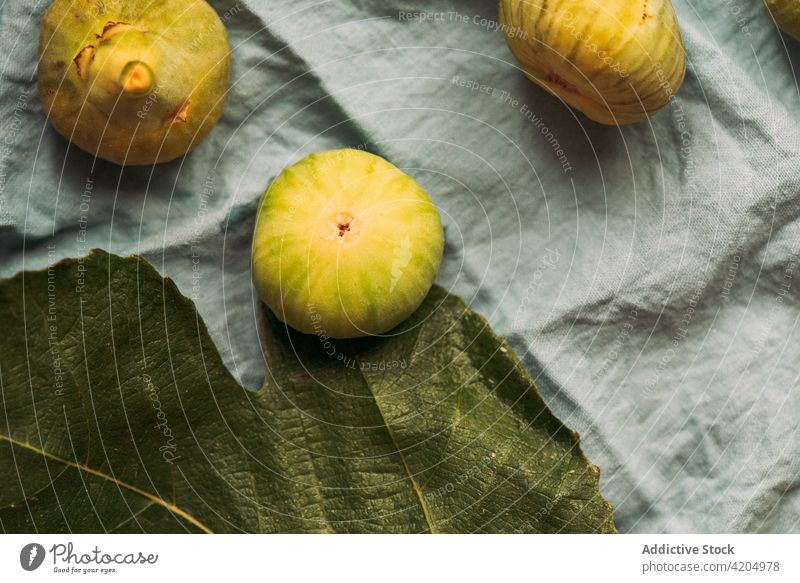 Ripe sweet green figs, freshly harvested on the pastel blue tablecloth. fruit ripe organic food diet nature healthy juicy raw freshness ingredient dessert