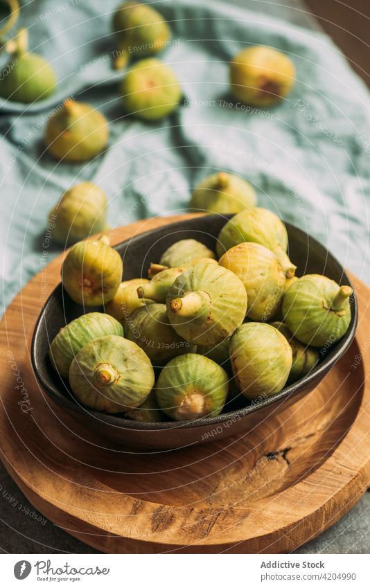 Fresh and ripe sweet green figs on the wood plate table fruit bowl organic food diet nature healthy juicy fresh raw freshness blue ingredient dessert closeup