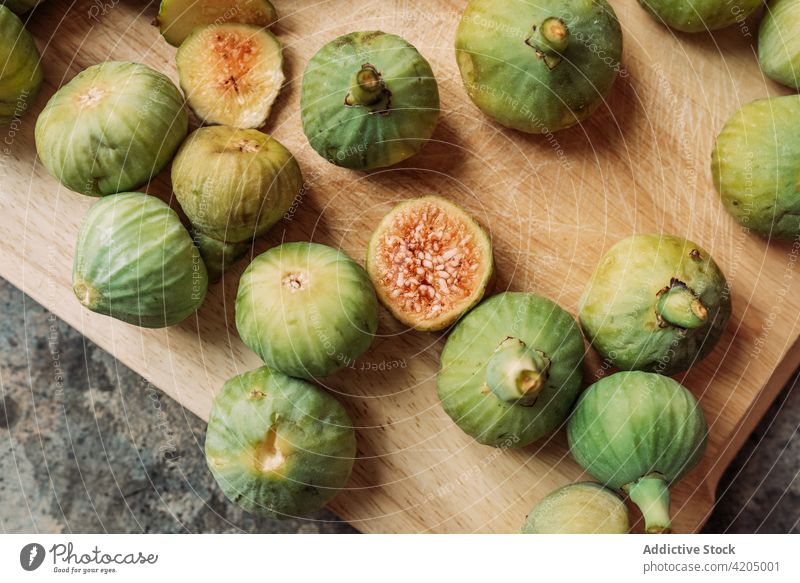Ripe sweet green figs on wood cutting board. table fruit ripe organic food diet sliced nature healthy juicy fresh raw freshness ingredient dessert exotic
