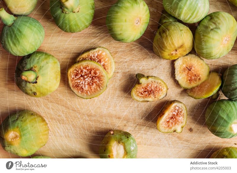 Ripe sweet green figs on wood cutting board. table fruit ripe organic food diet sliced nature healthy juicy fresh raw freshness ingredient dessert exotic