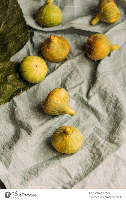 Ripe sweet green figs, freshly harvested on the pastel blue tablecloth. fruit ripe organic food diet nature healthy juicy raw freshness ingredient dessert