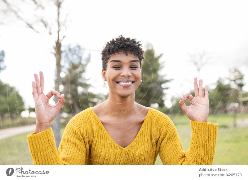Ethnic woman showing mudra gesture in park yoga smile nature hand sign harmony female ethnic black african american healthy wellness happy energy positive