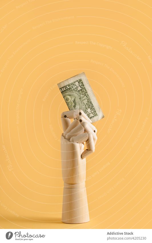 Dollar bill in wooden hand in studio dollar concept money cash banknote finance financial wealth mannequin budget save currency economy income profit investment