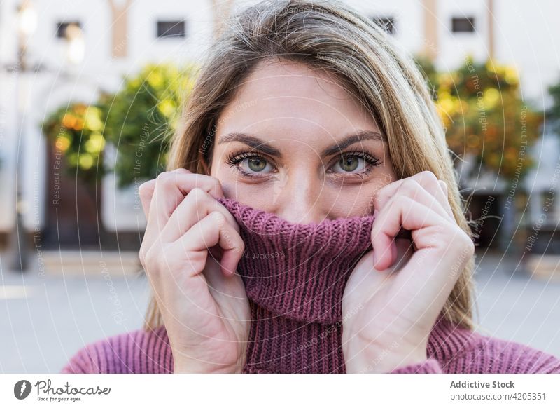 Woman in warm sweater on street cover face woman hide tender knitted city charming female delicate gentle outfit soft knitwear cover mouth content calm serene
