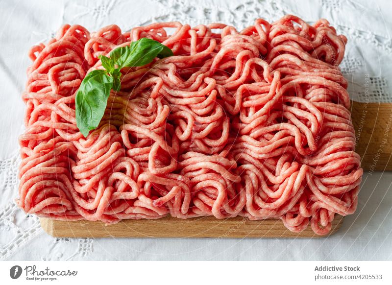Raw minced meat and basil leaves on table raw fresh cook culinary food prepare ingredient uncooked pork beef cuisine meal recipe kitchen product protein