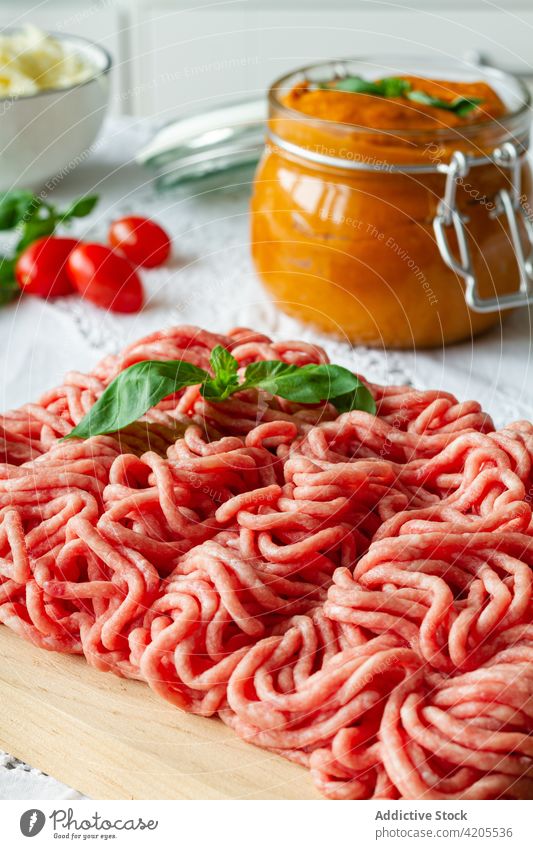 Raw minced meat and basil leaves on table raw fresh cook culinary food prepare ingredient uncooked pork beef cuisine meal recipe kitchen product protein