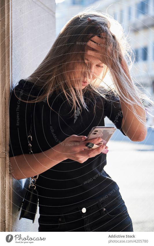 Woman using her smartphone looking worried woman Russian girl alone beautiful blond city city life cityscape day downtown elegant female formal long hair