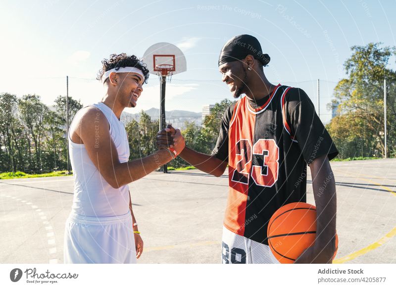 Black male basketball players shaking hands on court handshake men greeting gesture streetball playground together ethnic black african american game athlete