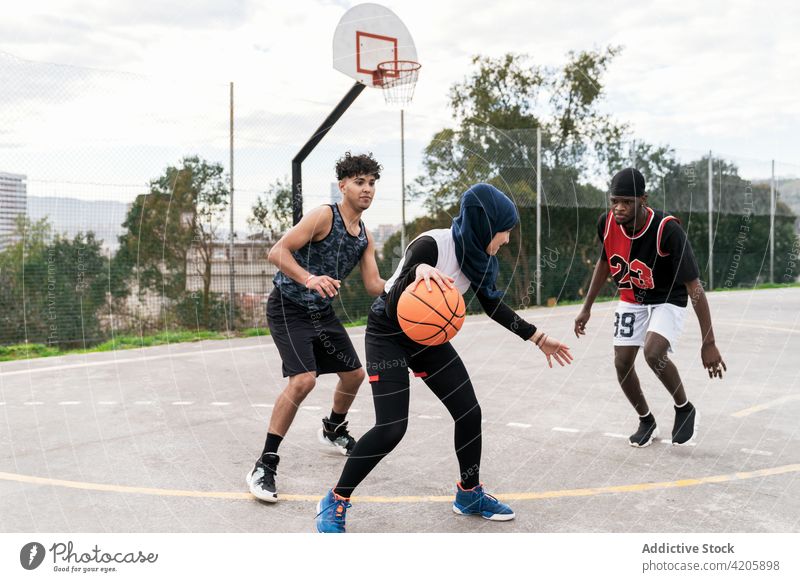 Diverse people playing basketball on court streetball player together game team sports ground multiracial multiethnic diverse black african american muslim
