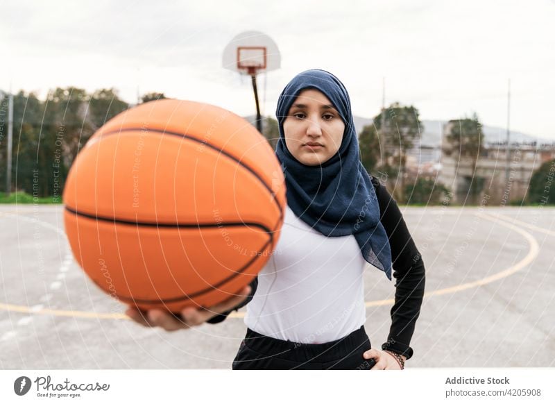 Ethnic woman with basketball on playground streetball workout player hijab court determine female muslim ethnic sport game activity hobby concentrate