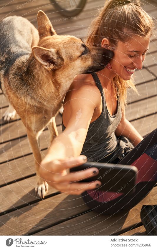 Cheerful female runner taking selfie with pet on smartphone woman german shepherd using break workout training fitness dog mobile animal friend gadget device