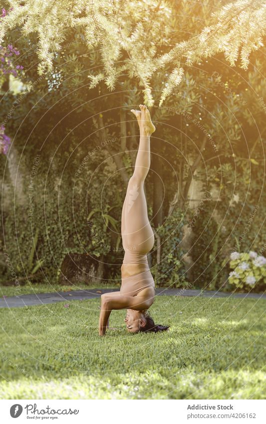 Woman showing handstand pose in park woman yoga balance Handstand practice smile stretch flexible wellbeing happy vitality Downward Facing Tree Pose