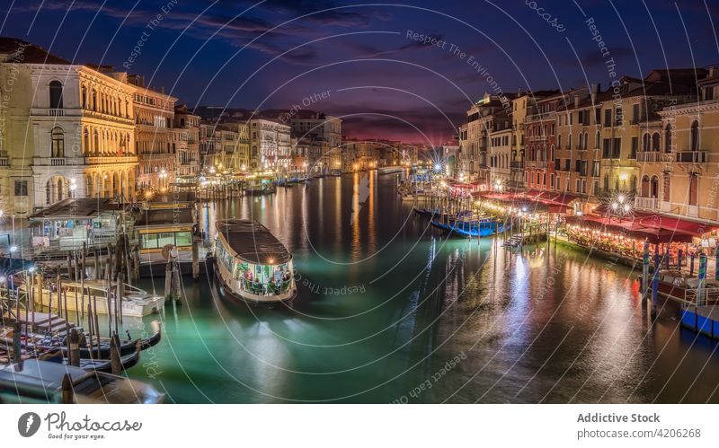 Water channel between buildings in night city grand canal water dark residential scenery venice italy shabby old exterior architecture illuminate light glow sky
