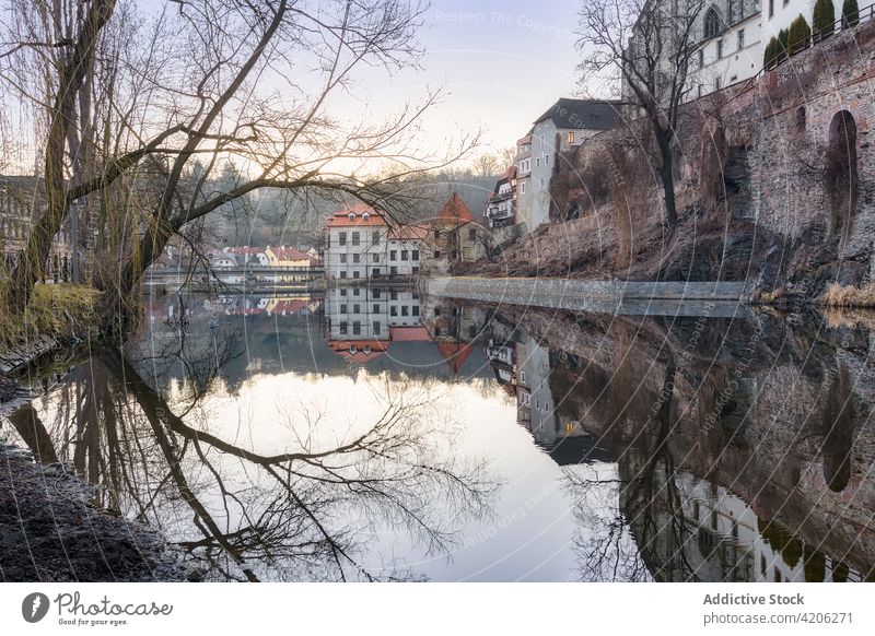 Old residential houses near river in city old building aged reflection shabby historic calm water town mirror surface waterfront picturesque tranquil shore