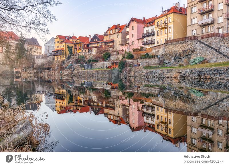Old residential houses near river in city old building aged reflection shabby historic calm water town mirror surface waterfront picturesque tranquil shore