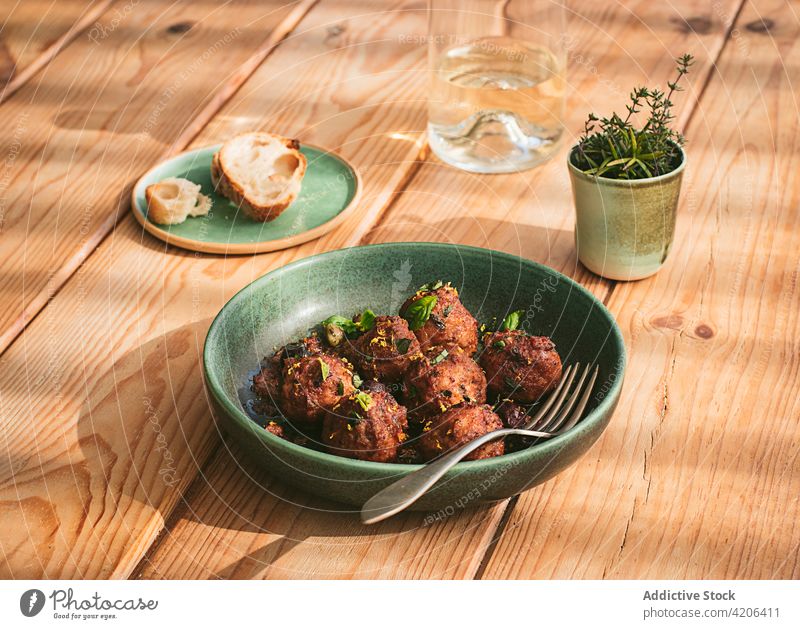 Closeup of a plate of meatloaf with some parsley cooked meatballs culture table menu stuffed stewed roast creamy sauce black olives capers sun dried tomatoes