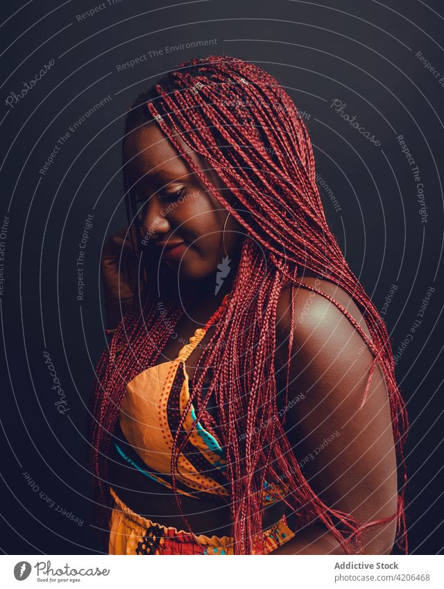 Content black woman with braids in studio hairstyle cheerful appearance beauty complexion long hair pink hair smile ethnic african american happy joy positive