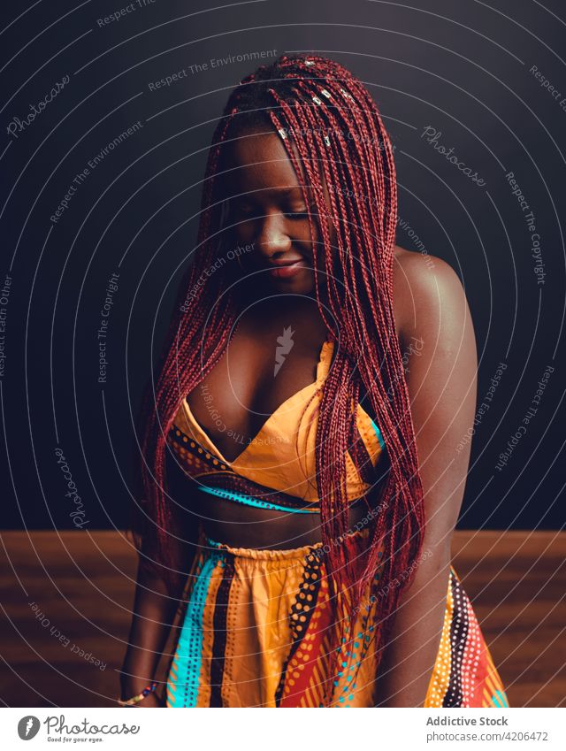 Content black woman with braids in studio hairstyle cheerful appearance beauty complexion long hair pink hair smile female ethnic african american happy joy