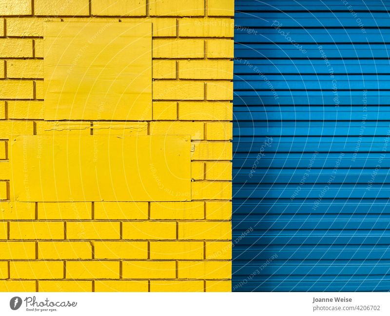 Yellow brick wall and blue roller door. blue and yellow yellow wall blue door Blue Door Colour photo Exterior shot Day Metal Architecture Building
