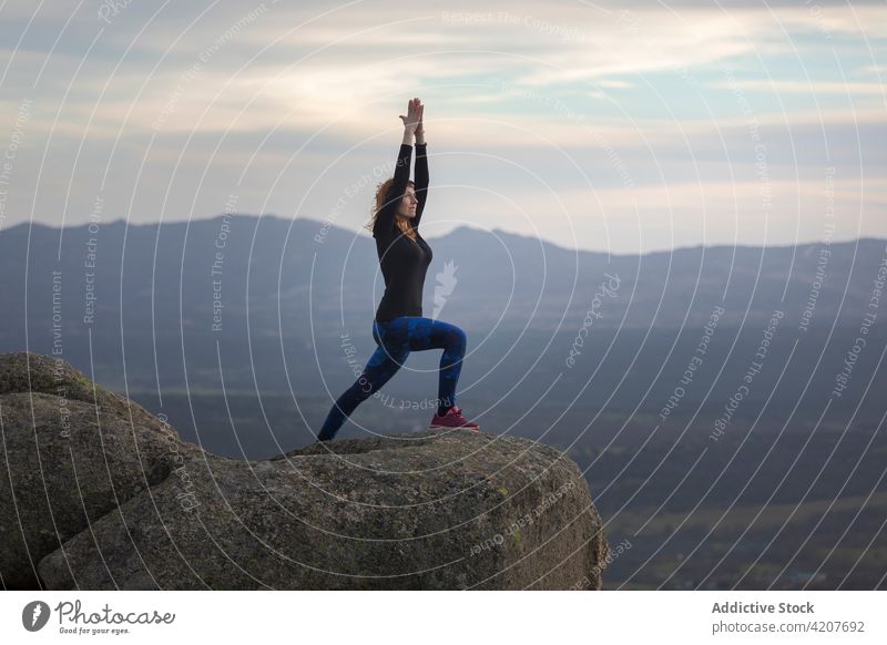 Woman performing Virabhadra on hilltop woman yoga Warrior one Pose recreation meditate nature flexible confident mountain female tree posture practice healthy