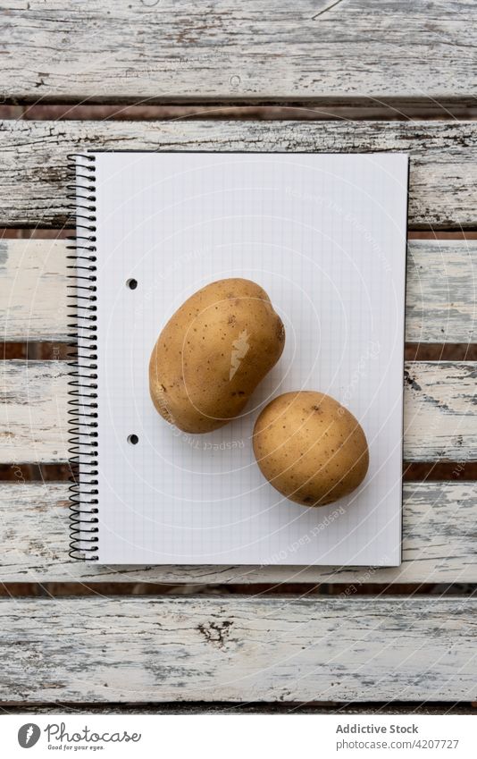 Two potatoes on blank notebook on table herb fresh greenery notepad healthy food desk paper page wooden natural minimal organic simple tasty delicious