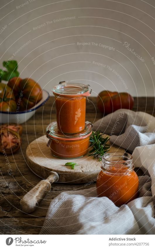 Glass pots with homemade fried tomato sauce on table handmade conserve fresh basil jar tasty condiment kitchen organic vegan culinary veggie healthy herb