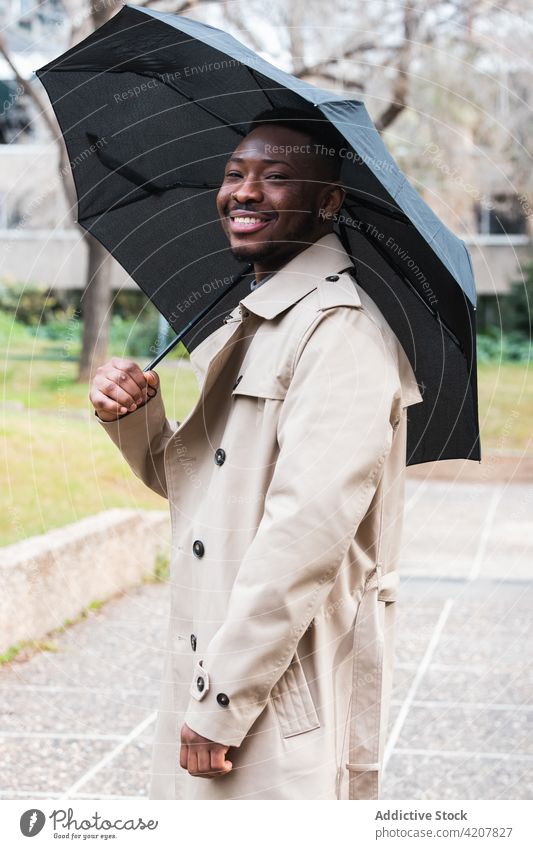 Happy stylish black man with umbrella coat spring style smile happy fashion weather trendy male adult african american ethnic urban cheerful modern lifestyle