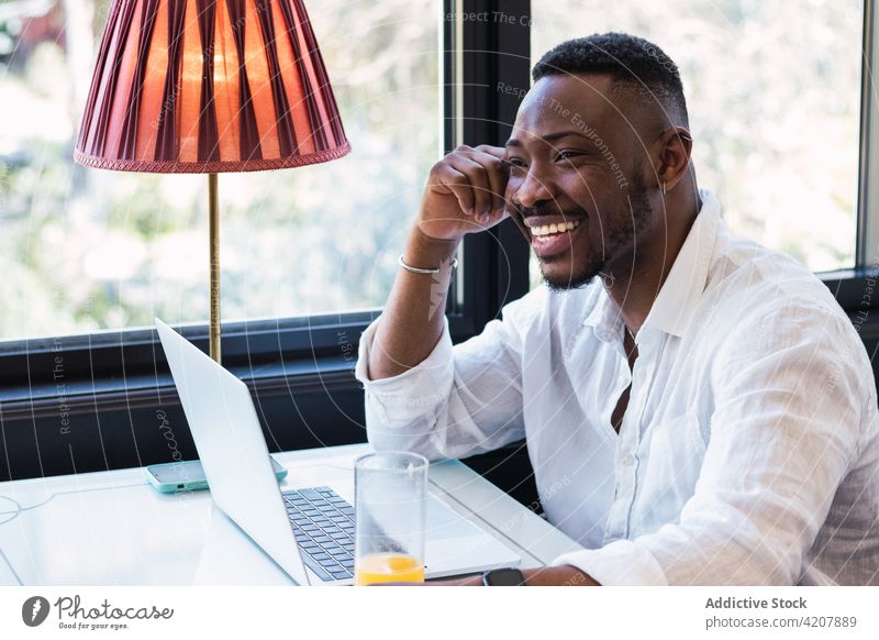 Black man working on laptop in cafe using remote browsing digital online freelance busy businessman male black ethnic african american gadget device internet