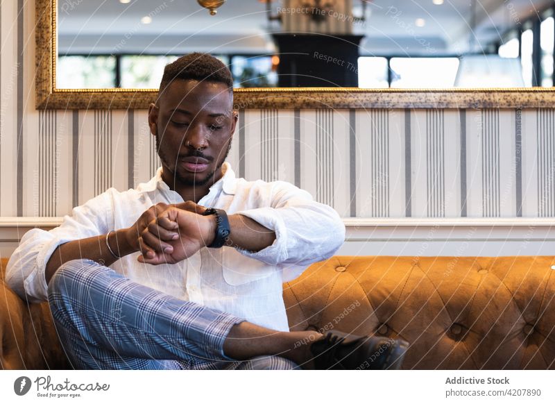 Stylish black man checking time on wristwatch style wait trendy serious punctual appointment businessman african american ethnic male lifestyle modern guy